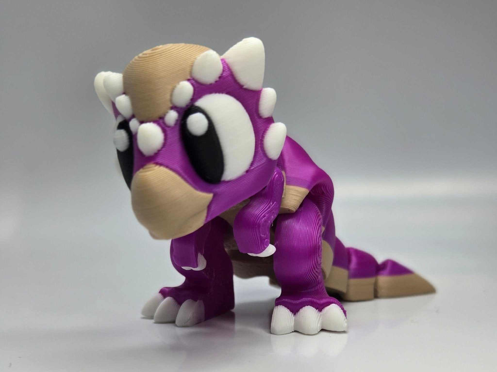Dinosaurierfigur Baby Stygimoloch – Beweglicher Dinosaurier aus violettem Kunststoff mit beigem Kopf und weißen Hörnern