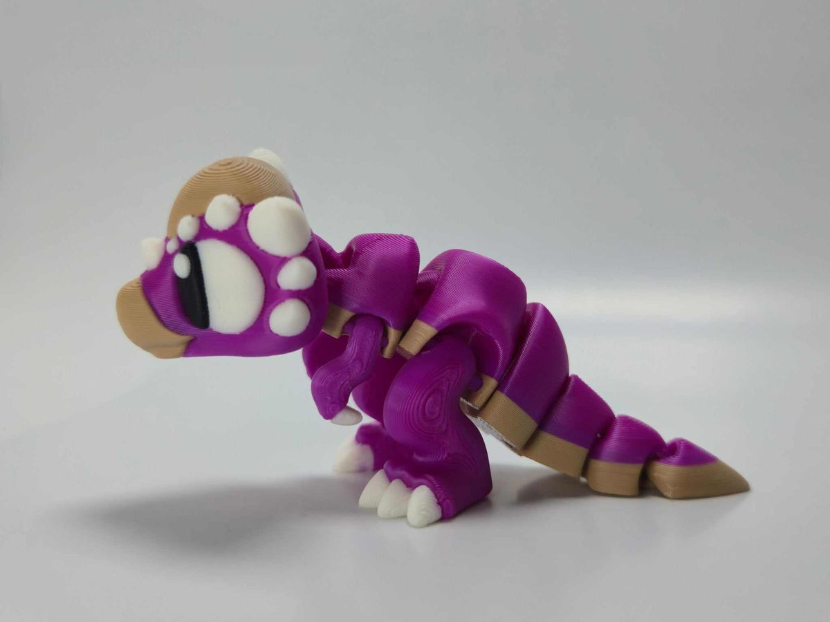 Dinosaurierfigur Baby Stygimoloch – Beweglicher Dinosaurier aus violettem Kunststoff mit weißen Noppen und Gliederschwanz