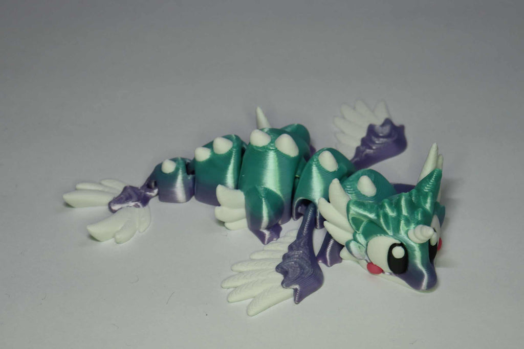Drachenfigur ProtoDrache Auroria aus Kunststoff in Türkis und Violett mit weißem Flügelpaar, Gliederkörper und großen Augen