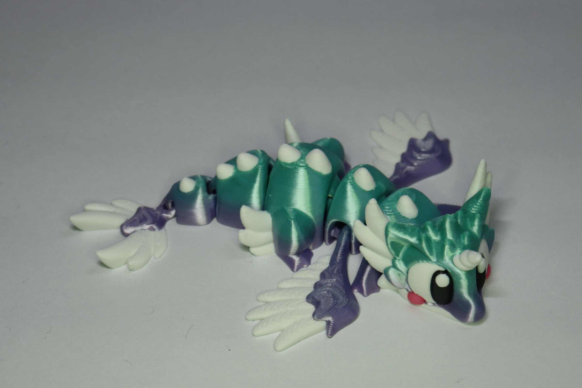 Drachenfigur ProtoDrache Auroria aus Kunststoff in Türkis und Violett mit weißem Flügelpaar, Gliederkörper und großen Augen