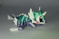 Drachenfigur ProtoDrache Auroria aus 3D-gedrucktem Kunststoff in Türkis und Violett mit hellen Flügeln und großen Augen